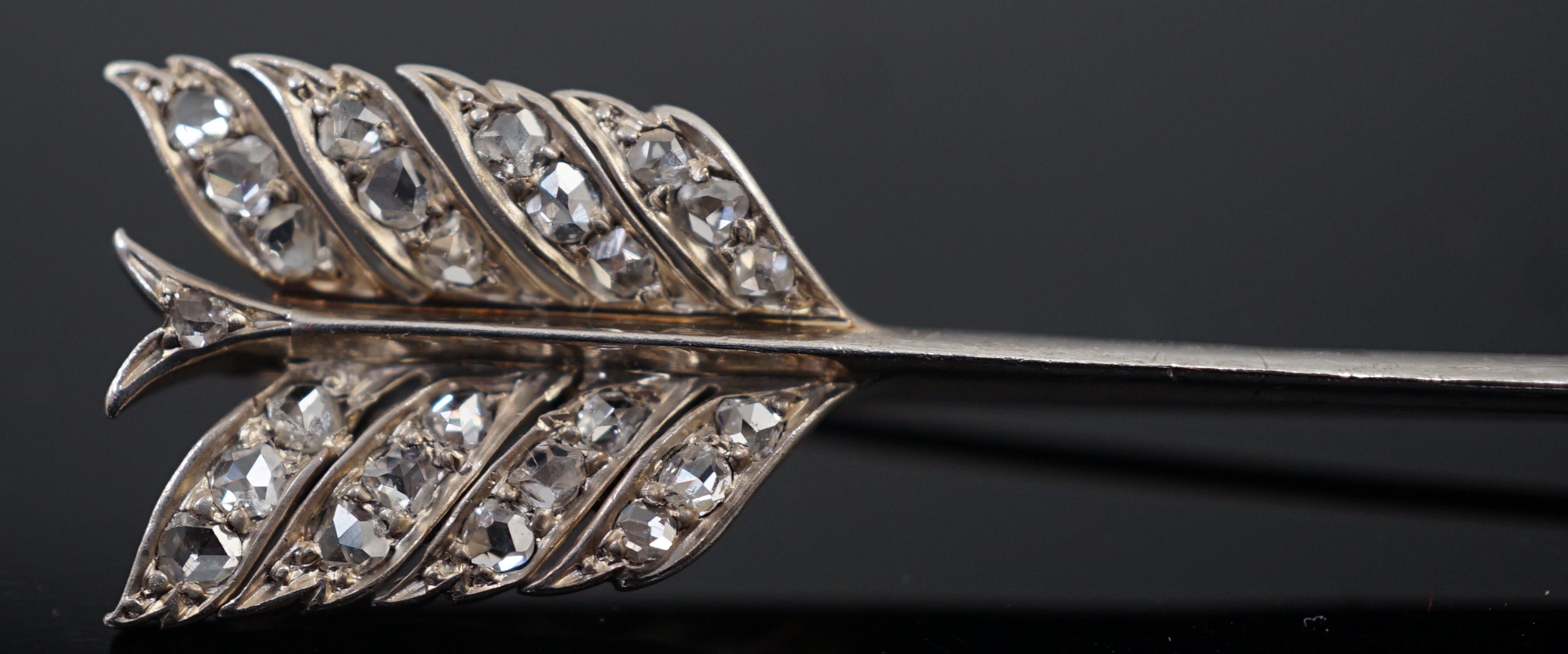 An early 20th century gold, platinum and rose cut diamond cluster set arrow brooch